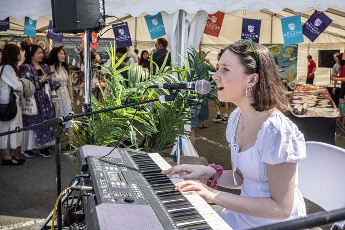 merch yn canu a chwarae piano