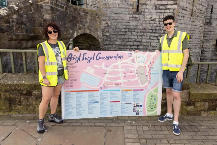 2 wirfoddolwr yn sefyll wrth map mawr